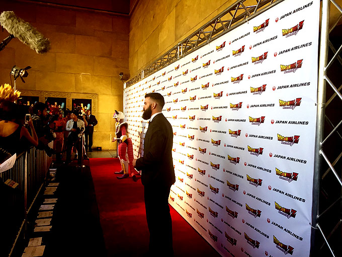 Walking the red carpet and pausing in front of step and repeat wall at Dragon Ball Z premiere