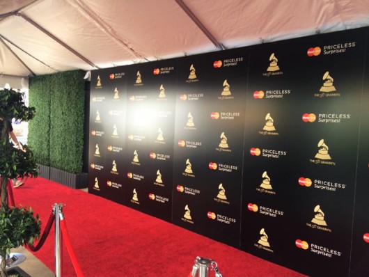 Black step and repeat backdrop, red carpet, velvet rope, tent and green hedges for MasterCard Rock the Carpet
